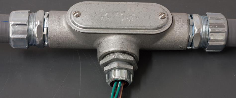 Conduit body with wires running through a fitting